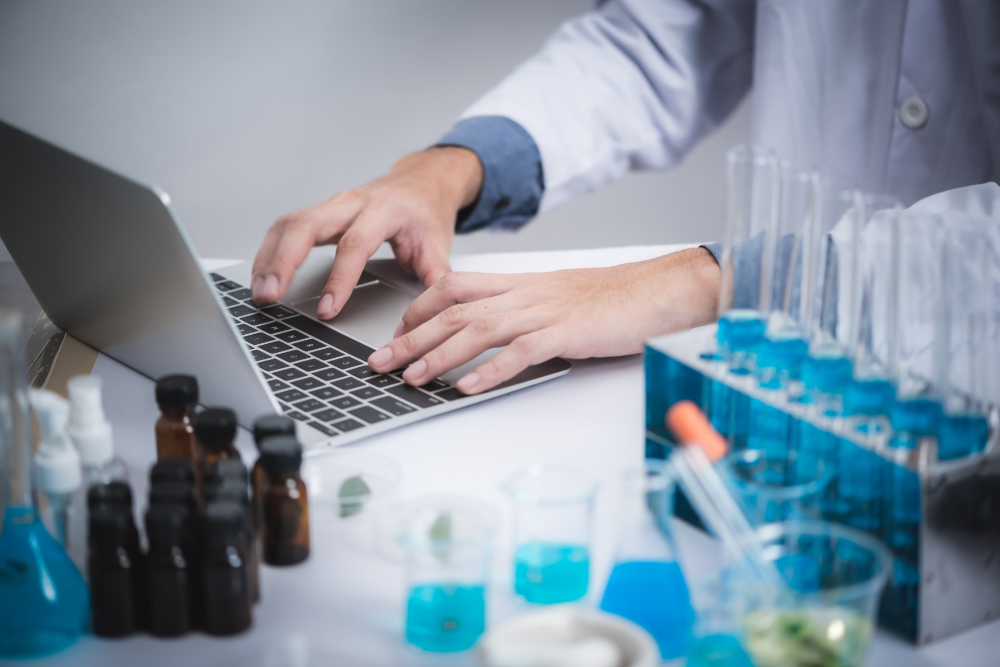 Ordinateur portable avec un graphique et flacons d'huiles essentielles – connaissances scientifiques sur les substances naturelles