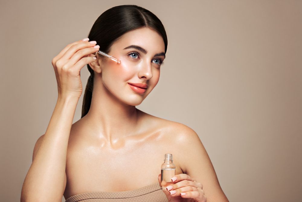 Femme appliquant un sérum naturel aux huiles essentielles sur le visage