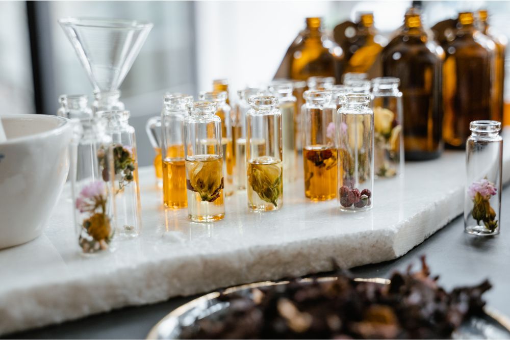 Petits flacons de différentes huiles essentielles de plantes aromatiques et herbes fraîches sur un support en bois – aromathérapie naturelle
