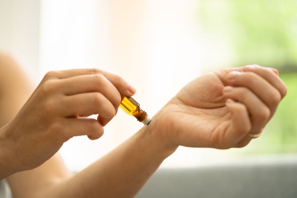 Application d'huile essentielle sur le poignet – exemple d'utilisation sûre de l'aromathérapie à la maison.